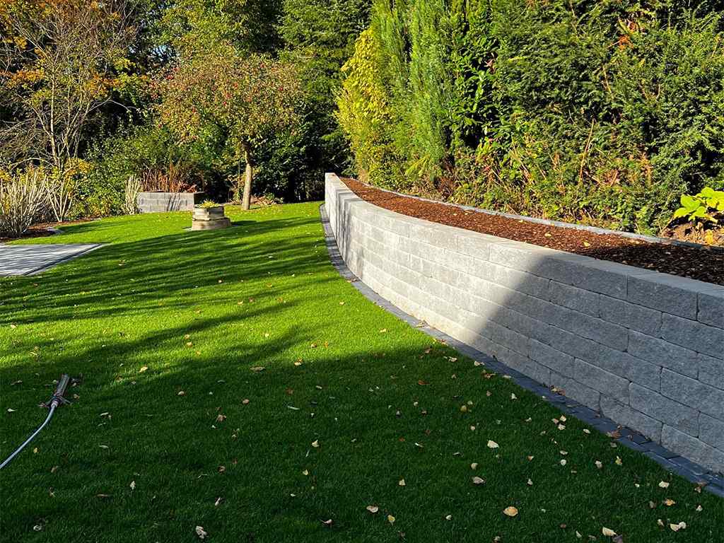 gepflegter Garten mit Natursteinmauer